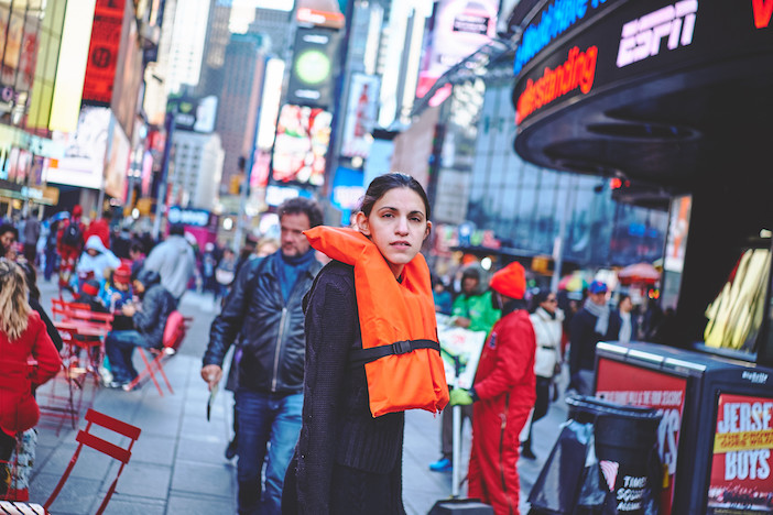 Georgia Lale wearing an orange life vest in the streets of New York for her #OrangeVest campaign