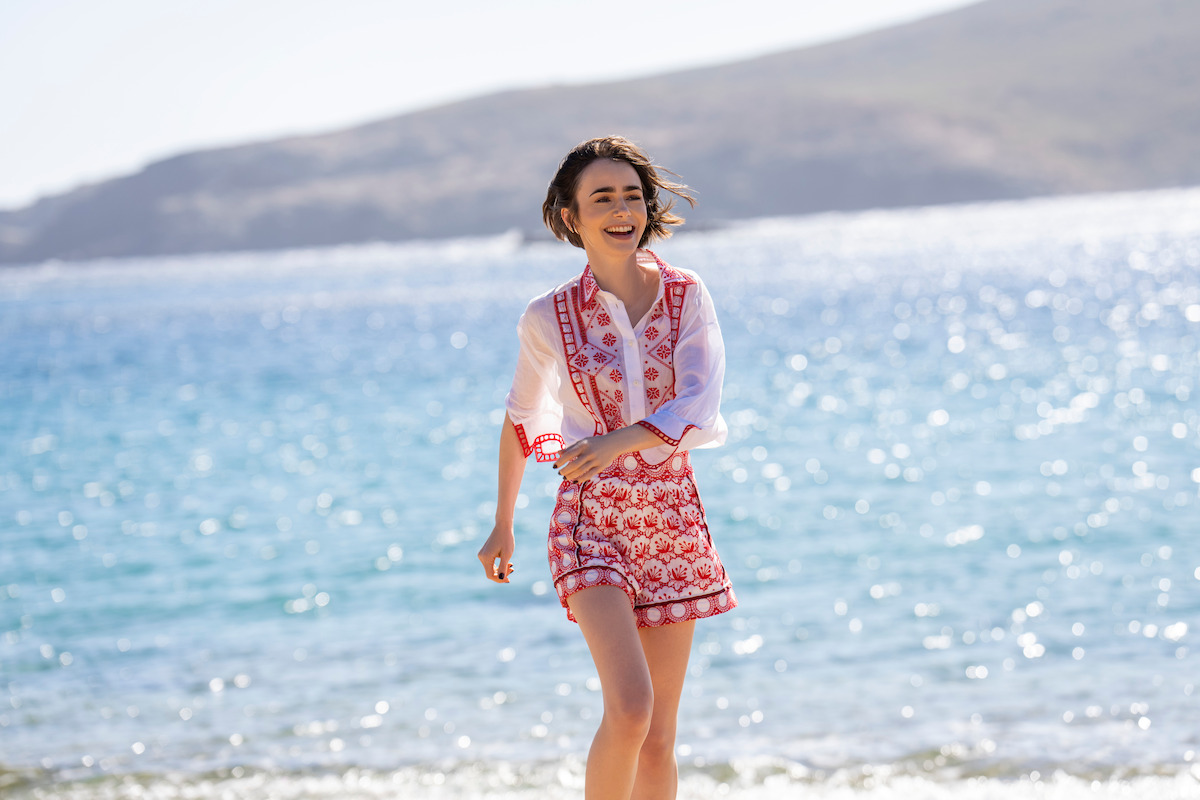 Lily Collins as Emily Cooper on a beach in Greece in Emily in Paris Season 6